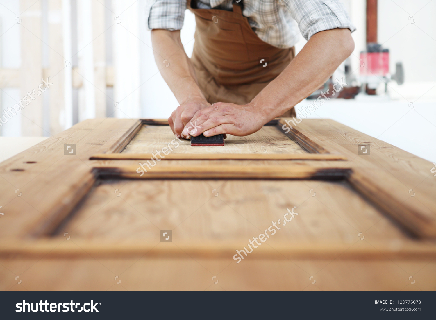 stock-photo-carpenter-work-the-wood-with-the-sandpaper-1120775078